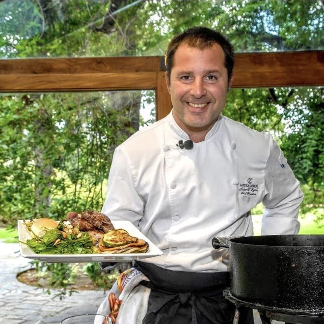 El chef Jaime Zapiola presentando un plato de carnes asadas